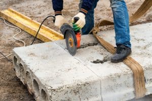 Close up worker cuts concrete with circular saw